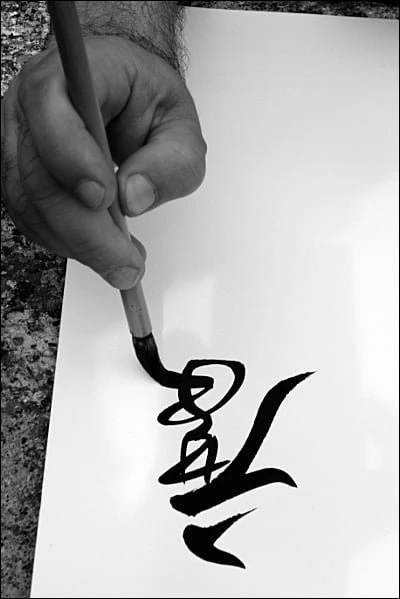 Maniement du pinceau de calligraphie chinoise tenu verticalement sur papier