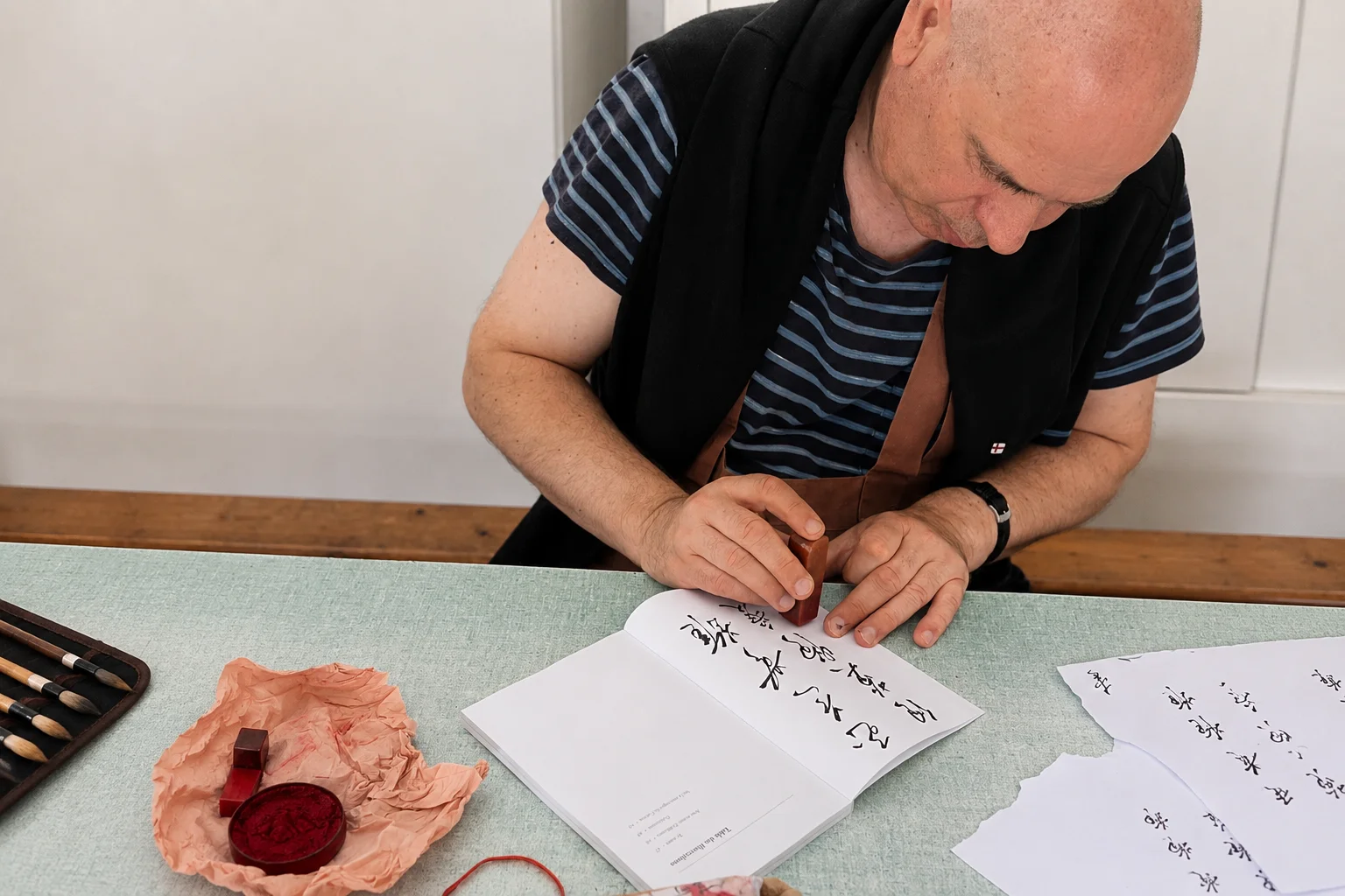 Christophe Desmur apposant son sceau traditionnel sur un ouvrage calligraphié