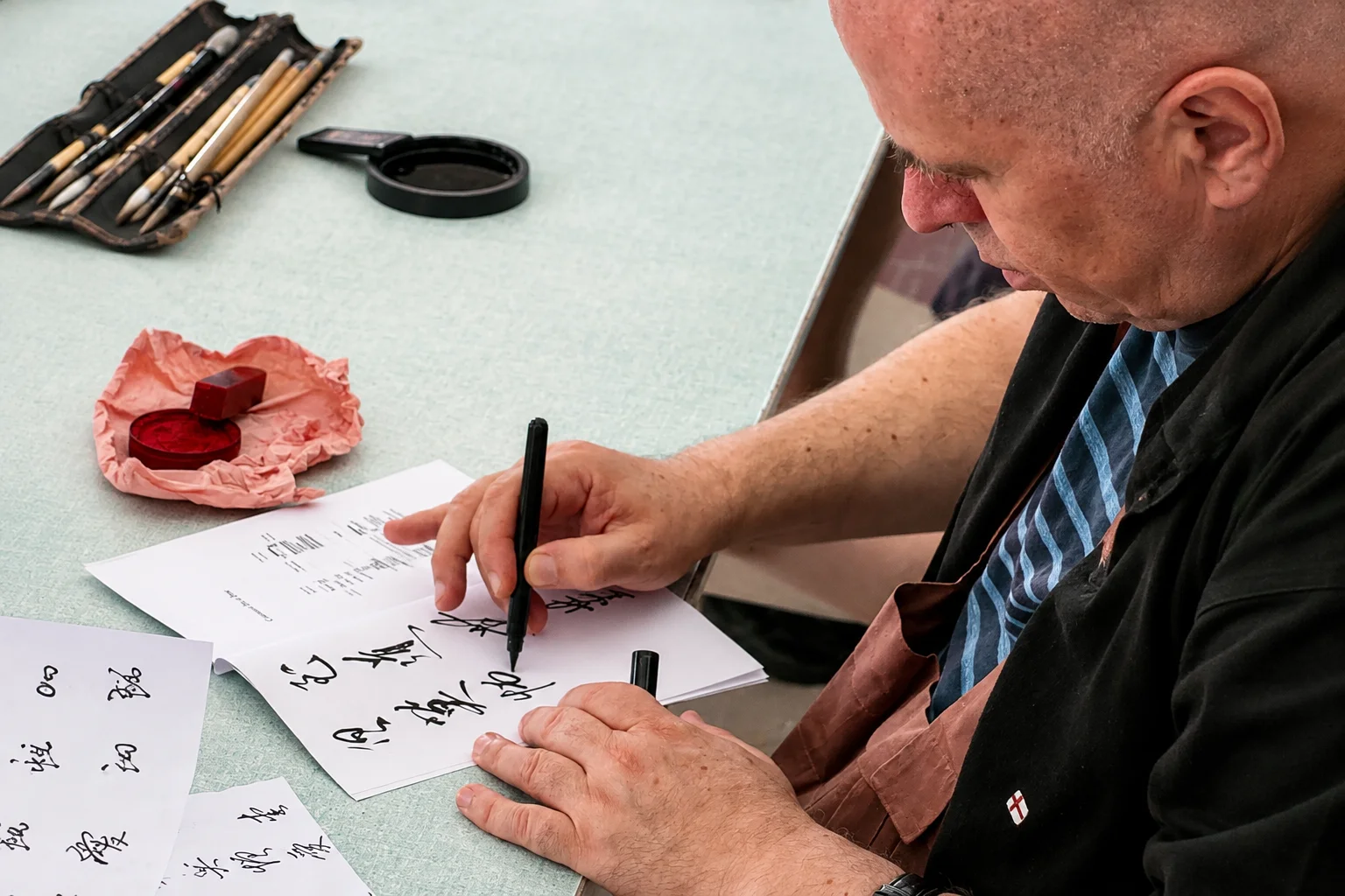 Christophe Desmur calligraphiant au pinceau pour ateliers en résidences seniors